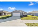 New construction home with gray siding, white garage door, and landscaping at 5 Pine Course Loop, Ocala, FL 34472