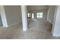 Spacious living room with light grey carpet and tile flooring near the entry at 5322 Sw 137Th Ct, Ocala, FL 34481