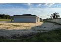 Rear view of a single-story house with a sandy yard at 6574 Se 108Th Ln, Belleview, FL 34420