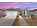 Two-story home with gray siding, white garage door, and landscaping at 7094 Sw 60Th Ln, Ocala, FL 34474