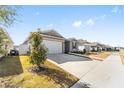 Single-story home with gray siding, white garage door, and landscaping at 7094 Sw 60Th Ln, Ocala, FL 34474