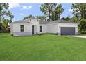 One-story house with gray garage and stone accents at 7759 Sw 139Th Street Rd, Ocala, FL 34473