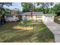 Charming ranch home with white exterior, wood accents, and landscaped yard at 900 Mulberry St, Fruitland Park, FL 34731