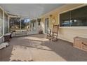 Bright screened porch features a rocking chair and wooden bench at 20635 Sw 63Rd Pl, Dunnellon, FL 34431