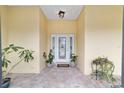 Front entry with tiled flooring, and potted plants at 21590 Sw 84Th Loop, Dunnellon, FL 34431