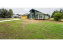 Eye-catching green house with a yellow garage door and lush green lawn at 2831 Sw 139Th St, Ocala, FL 34473