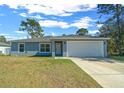 Newly built home with gray exterior, white garage door, and landscaped lawn at 307 Marion Oaks Pass, Ocala, FL 34473