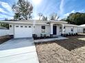 One-story house with gray exterior, white garage door, and stone accents at 4310 Se 139Th Pl, Summerfield, FL 34491