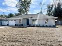 Newly built home features a gray exterior, white garage door, and a neatly landscaped front yard at 4310 Se 139Th Pl, Summerfield, FL 34491