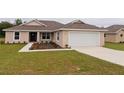 One-story house with a two-car garage and landscaped front yard at 6725 Sw 64Th Ave, Ocala, FL 34476