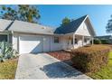 Inviting single-story home showcasing an attached garage, a well-maintained lawn, and a charming covered porch at 8569 Sw 92Nd Ln # F, Ocala, FL 34481