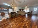 Open concept kitchen with island, wood cabinets, and hardwood floors at 9581 Se 168Th Elderberry Pl, The Villages, FL 32162