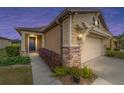 Tan house with a brown door and attached garage at dusk at 9661 Sw 63Rd Loop, Ocala, FL 34481