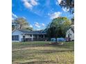 Single-story home with an attached garage, front porch, and a lush green lawn at 10820 Sw 80Th Ct, Ocala, FL 34481