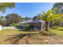 Home's backyard with screened patio and palm trees at 12750 Se 119Th Ct, Ocklawaha, FL 32179