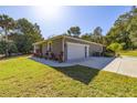 Attached garage with landscaping and driveway at 12750 Se 119Th Ct, Ocklawaha, FL 32179