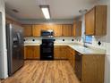 Spacious kitchen featuring wood cabinets, stainless steel appliances, and laminate flooring at 13410 Sw 3Rd Ct, Ocala, FL 34473