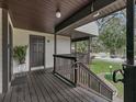 Wooden deck with railing, offering a view of trees and parking at 21202 Sandalwood Dr # 21-202, Wildwood, FL 34785