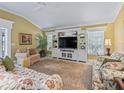 Living room with built-in shelving and large TV at 3416 Eisenhower Way, The Villages, FL 32163