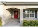Red front door with arched entryway and sidelights at 4480 Nw 79Th Terrace Rd, Ocala, FL 34482
