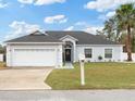 Charming single-story home with a well-manicured lawn, a welcoming front door, and an attached two-car garage at 4880 Sw 106Th St, Ocala, FL 34476