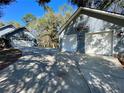 Spacious detached two-car garage with blue siding and white doors, set among mature trees at 6701 Se 99Th Pl, Belleview, FL 34420