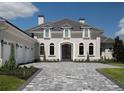 Elegant home features a gray stone driveway and manicured lawn at 7647 Nw 33Rd Pl, Ocala, FL 34482