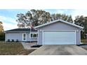 Spacious two-car garage with white door and landscaping at 8512 Sw 107Th N Pl, Ocala, FL 34481