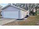 Attached garage with white door and landscaped walkway at 8512 Sw 107Th Pl, Ocala, FL 34481