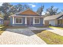 Quaint craftsman home with gray siding, paver driveway and walkway at 11759 Bostick St, Dunnellon, FL 34432