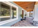 Covered front porch with wood ceiling, stone columns and brick flooring at 11759 Bostick St, Dunnellon, FL 34432