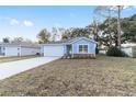 Newly built home with light blue exterior, white garage door, and stone accents at 13824 Se 42 Ave, Summerfield, FL 34491