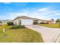 House exterior showcasing a paved driveway and manicured lawn at 13957 Se 86Th Cir, Summerfield, FL 34491