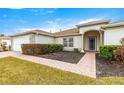 House exterior with a paved walkway and neatly trimmed shrubs at 13957 Se 86Th Cir, Summerfield, FL 34491