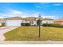 Single-story house with a two-car garage and landscaped lawn at 13957 Se 86Th Cir, Summerfield, FL 34491