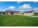 Charming home featuring a metal roof, a two-car garage, and a well-manicured lawn at 14130 Sw 8Th Ave, Ocala, FL 34473