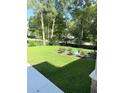 Lush backyard with green grass and mature trees, offering privacy and shade at 14268 Se 27Th Ct, Summerfield, FL 34491