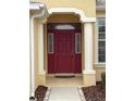 Elegant red front door entry with sidelights and arched columns at 16052 Sw 15Th Ct, Ocala, FL 34473