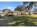 House with a spacious lawn, large oak trees and a view of a neighboring house at 2575 Se 34Th St, Ocala, FL 34471