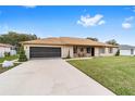 Tan house with brown roof, screened garage, and large yard at 4535 Nw 34Th Pl, Ocala, FL 34482