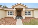 Home entrance with stone columns and a wooden door at 4933 Sw 109Th Loop, Ocala, FL 34476