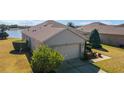 Rear exterior of home with a well-maintained roof, a two-car garage, and lush green landscaping at 9836 Sw 75Th Street Rd, Ocala, FL 34481