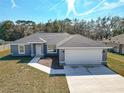 New construction home, gray exterior, two-car garage, and driveway at 201 Locust Rd, Ocala, FL 34472