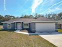 Gray house with a two-car garage, stone accents, and a walkway at 201 Locust Rd, Ocala, FL 34472