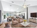 Bright, open-concept living room with a ceiling fan, dining area and modern kitchen at 201 Locust Rd, Ocala, FL 34472