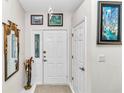 Bright entryway with white door and mirror at 3923 Manor Oaks Ct, Leesburg, FL 34748