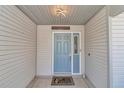 Inviting front door with sidelight and covered entrance, creating a warm and welcoming ambiance at 3923 Manor Oaks Ct, Leesburg, FL 34748