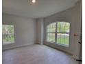 Bright bedroom featuring tile flooring, base trim and ample natural light from two windows at 6915 Sw 152Nd St, Ocala, FL 34473
