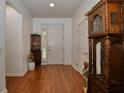 The foyer features shiny wood floors, white walls, and decorative shelves at 7387 Sw 99Th Ct, Ocala, FL 34481