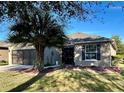 Charming home featuring a well-manicured lawn, palm tree, and neutral stucco exterior at 7387 Sw 99Th Ct, Ocala, FL 34481